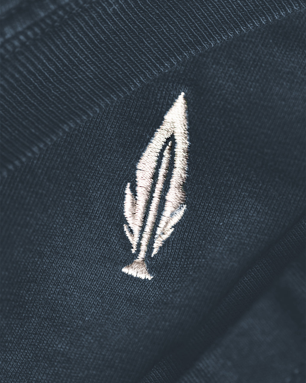 Feather and Hide logo on a blue tshirt
