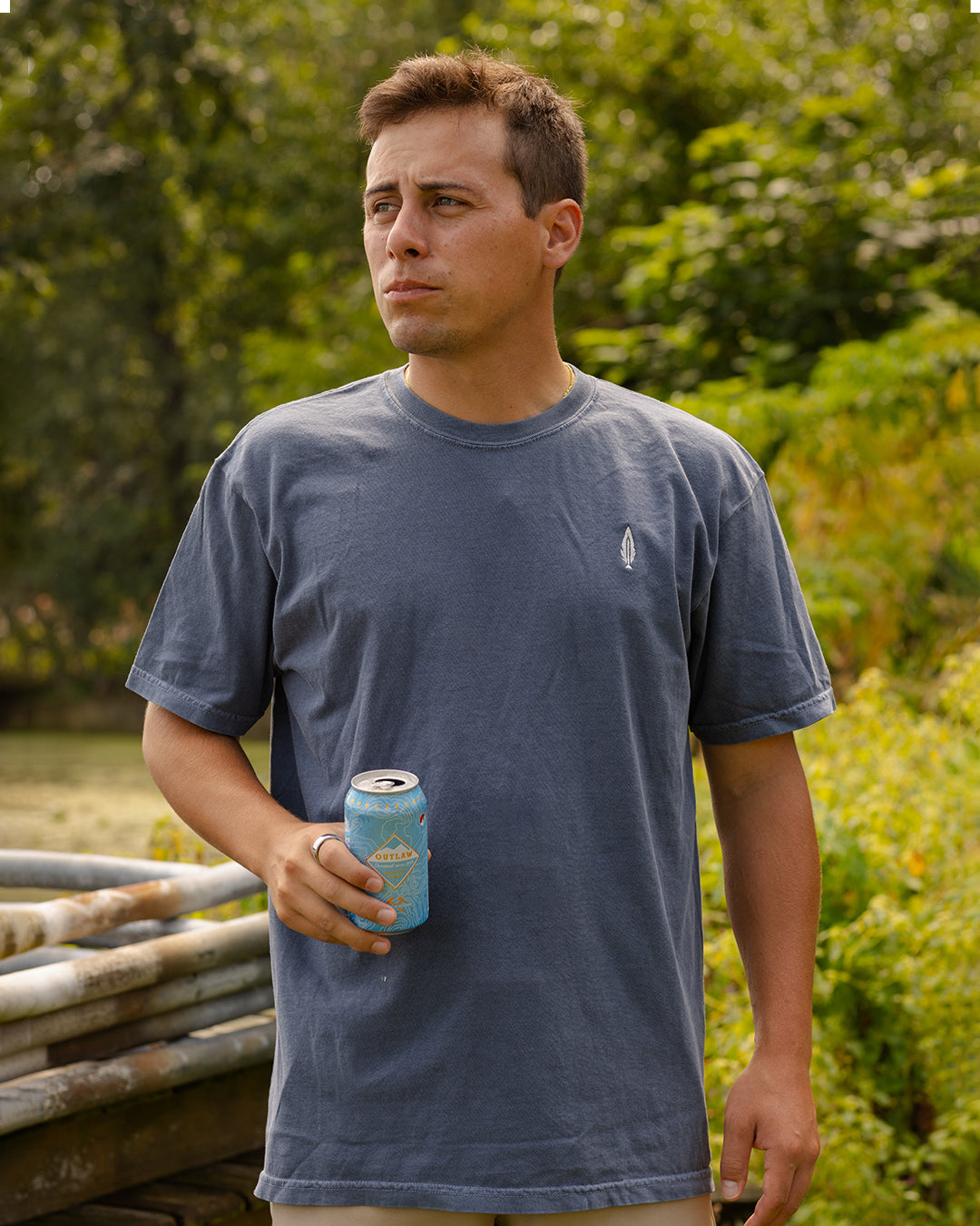 Feather and hide blue golf shirt worn by a man drinking a beer