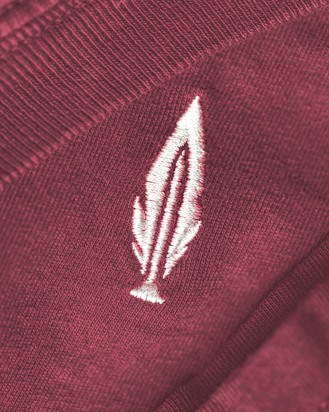 Feather and Hide logo on a red tshirt