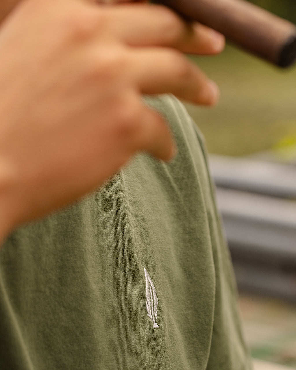 Feather and Hide golf logo on a green tshirt