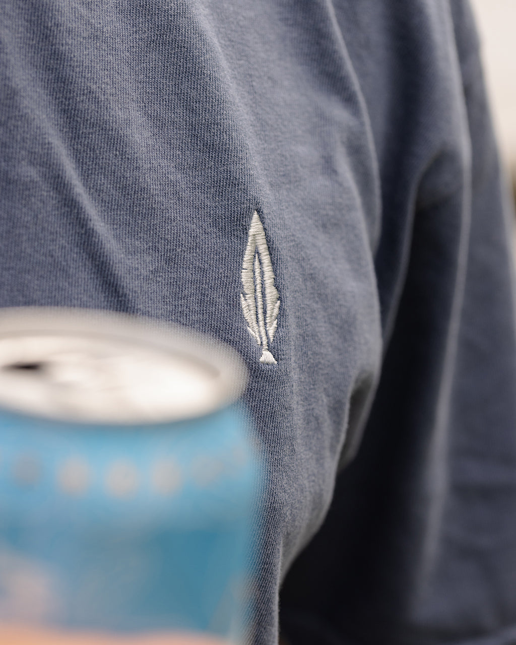 Feather and Hide logo on a blue golf tshirt