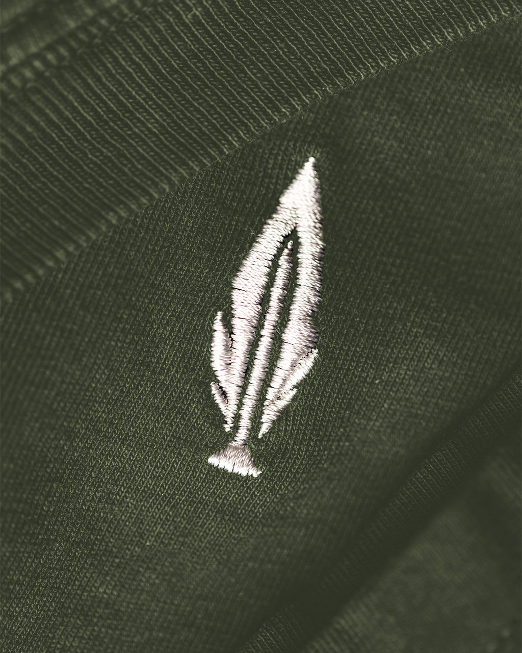 Feather and Hide logo on a green tshirt