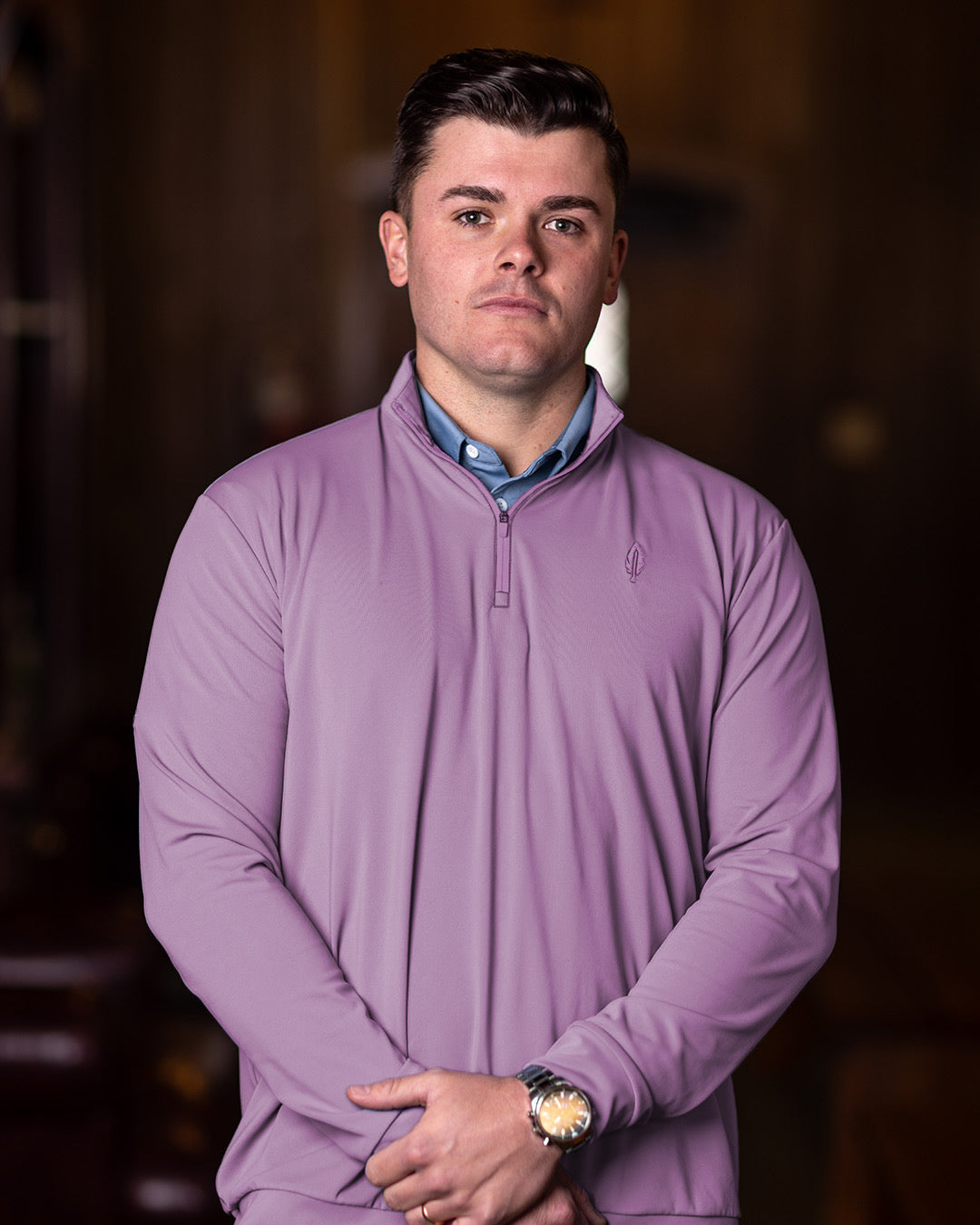 Man wearing a purple long-sleeve shirt with a blurred background