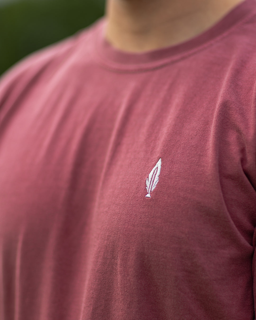 Feather and Hide logo on a red tshirt