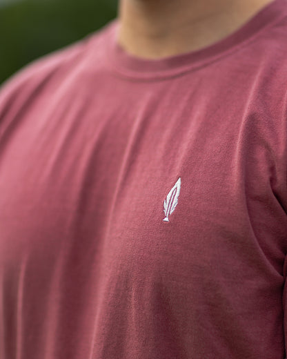 Feather and Hide logo on a red tshirt