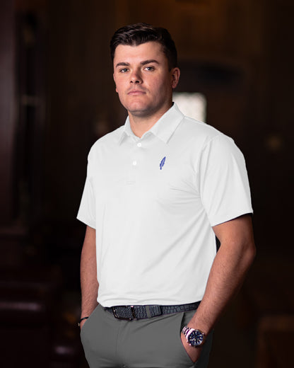 Man wearing a white polo shirt with a logo in an indoor setting