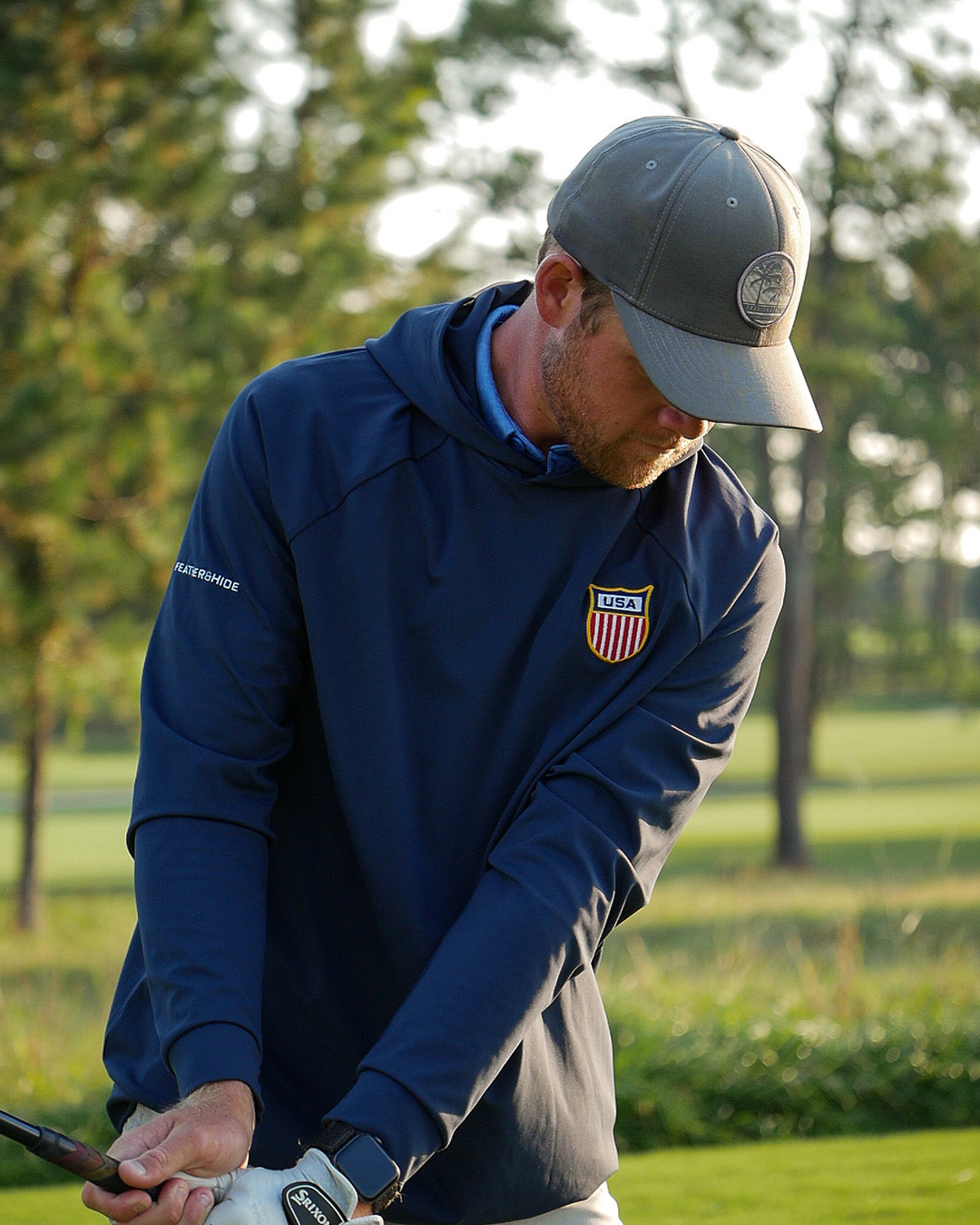 Golfer in a Feather and Hide golf hoodie with a limited edition USA patch